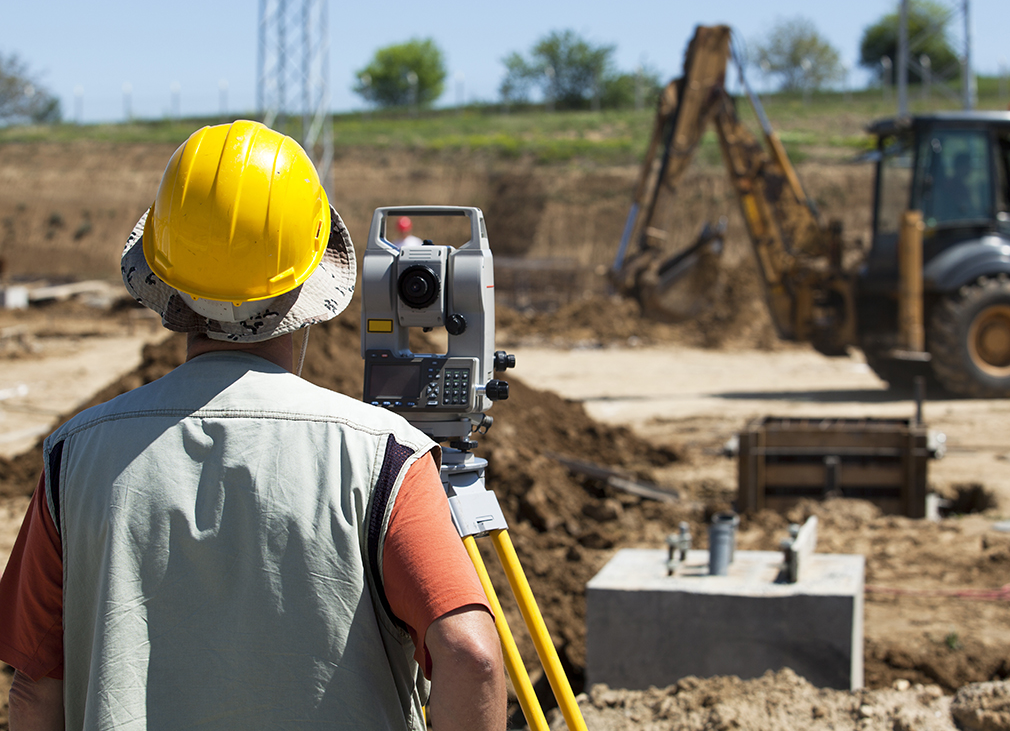 Surveyor working on construction site.